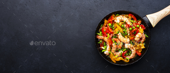 Stir fry with shrimps, red and yellow paprika, green pea, chives and sesame seeds  - Stock Photo - Images
