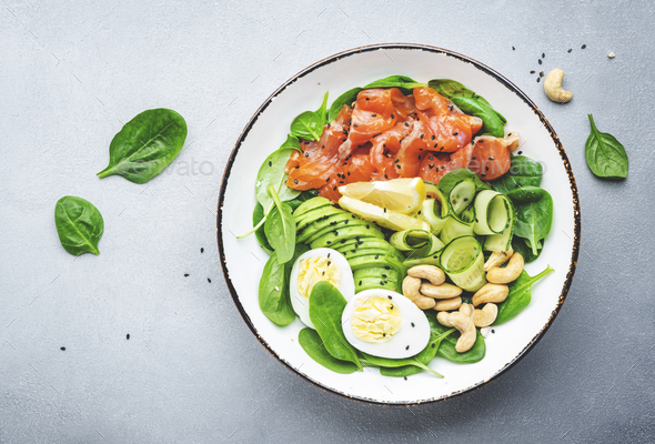 Keto salad bowl with salmon, avocado, spinach, cucumber, eggs, cashew nuts - Stock Photo - Images