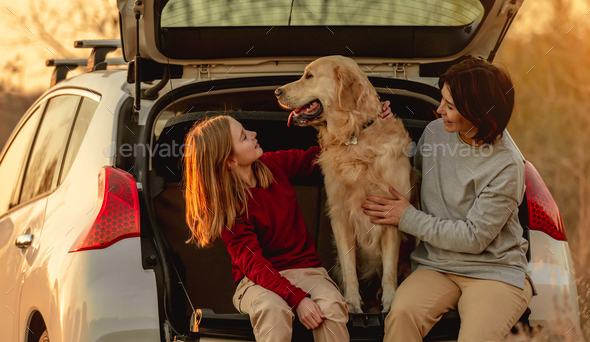 Family with golden retriever dog in car