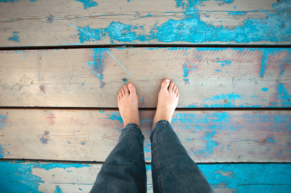 Foot of a tourist woman on blue wooden plank on the beach. Holidays and vacations in summer. - Stock Photo - Images