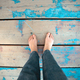 Foot of a tourist woman on blue wooden plank on the beach. Holidays and vacations in summer. - PhotoDune Item for Sale