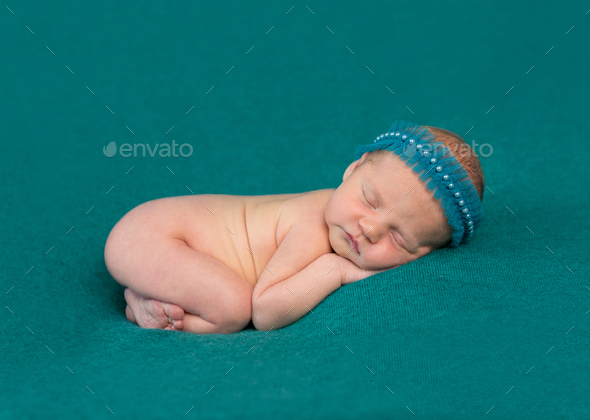 sweet newborn sleeping on stomach and hands with headband Stock Photo by  tan4ikk