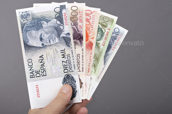 Spanish money in the hand on a gray background - Stock Photo - Images
