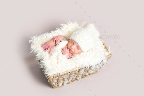 Newborn baby asleep on back with legs curled up