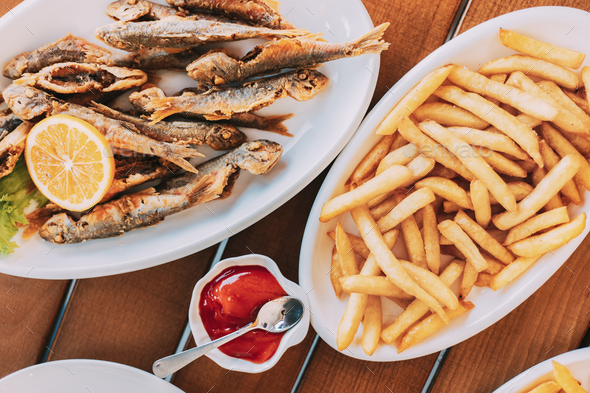 french fries and grilled fishes. fish and chips. Dish with Mullet Fish With orange. Fried fry small - Stock Photo - Images