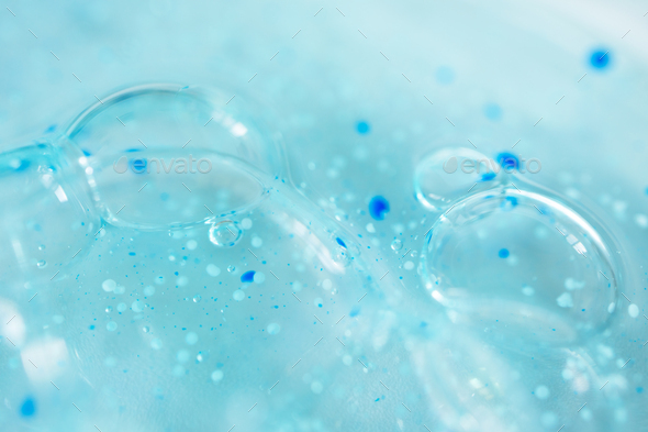 Close-up bubble blue shower gel with scrub grain texture with selective focus