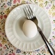 Egg on white plate with fork on spring flower background - PhotoDune Item for Sale