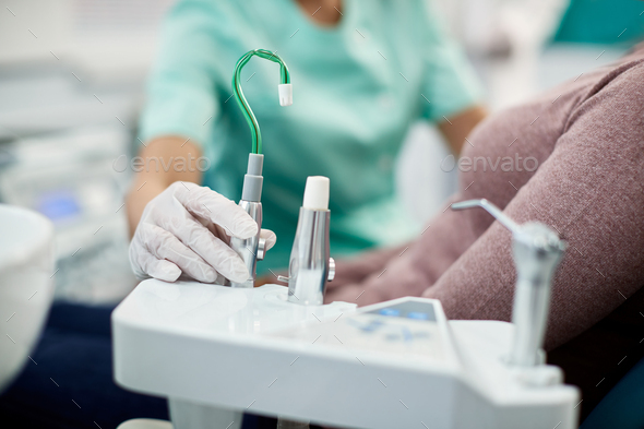 Close up of dentist using suction tube during dental procedure.