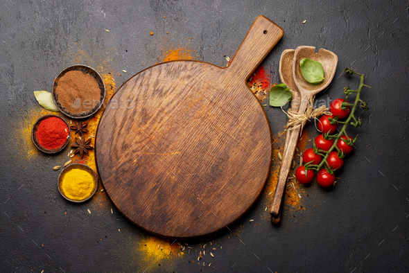 Empty cutting board over various spices - Stock Photo - Images