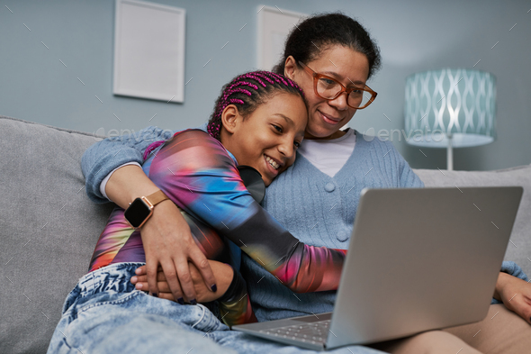 Mother and daughter using laptop together - Stock Photo - Images