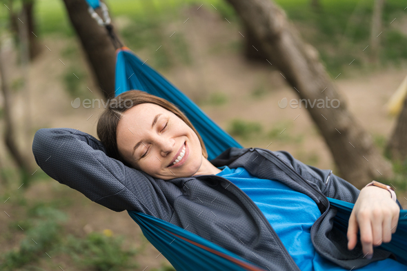 Smiling woman resting in a hammock - Stock Photo - Images
