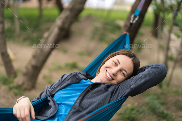 Smiling woman resting in a hammock - Stock Photo - Images