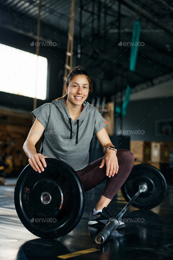 A happy female personal trainer is looking at the sportswoman who