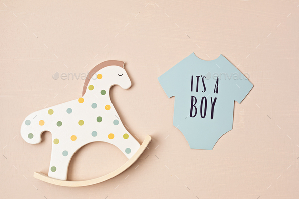 Baby shower, gender reveal party. It\'s a boy message over paper cut onesie