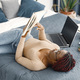 Young teenage girl lying on her bed studying in light bedroom at home - PhotoDune Item for Sale