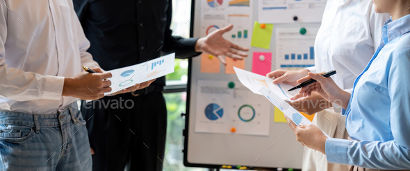 Group of confident business people point to graphs and charts to analyze market data, balance sheet - Stock Photo - Images