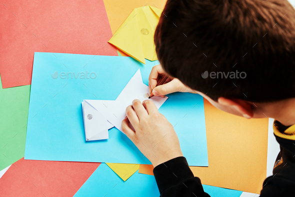 Boy making paper dog origami - Stock Photo - Images