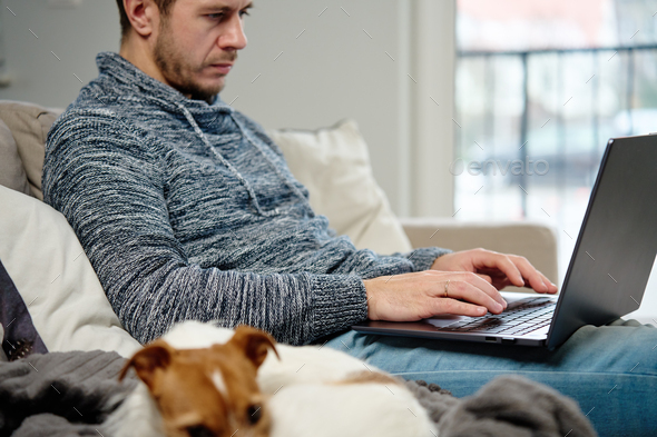 Man using laptop at living room - Stock Photo - Images