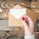 Blank postcard and envelope in female hands on a blurred wooden background. - PhotoDune Item for Sale