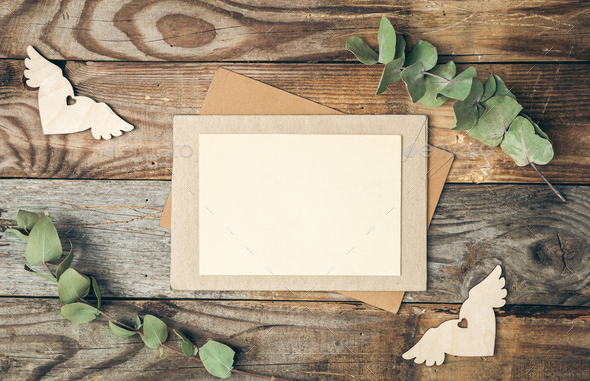 Blank paper and envelope on wooden background with eucalyptus twigs, flat lay. - Stock Photo - Images