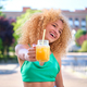 Young Brazilian woman laughing and holding a drink in a summer day. - PhotoDune Item for Sale