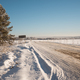 Countryside snowy road in meadow in winter sunny day - PhotoDune Item for Sale