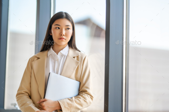 asian woman looking outside window - Stock Photo - Images