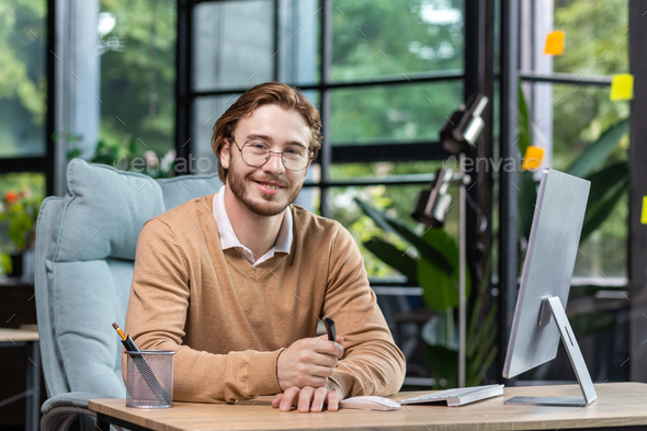 Portrait of successful smiling programmer inside modern green loft office, blond man smiling and - Stock Photo - Images