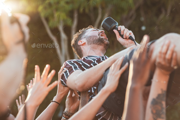 Crowd, surfing and man singing at party, outdoor music festival or social gathering. Microphone, en