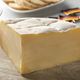 Piece of fresh Brugge Blomme cheese close up on a cutting board - PhotoDune Item for Sale