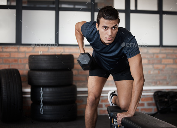 Fitness, bench and dumbbell with a sports man training in a gym for strong or healthy muscles. Mind