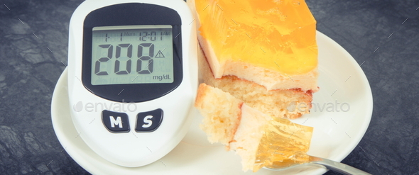 Glucometer with high sugar level and creamy fruit cake with jelly - Stock Photo - Images