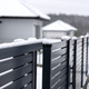 Modern anthracite panel fence with falling snow, visible sliding gate. - PhotoDune Item for Sale