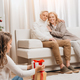 selective focus of happy grandparents and granddaughter with gift boxes sitting on floor - PhotoDune Item for Sale