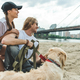 beautiful young couple with dog on beach looking away - PhotoDune Item for Sale