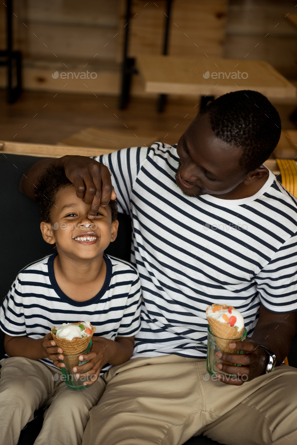 Happy African American Father And Son Eating Ice Cream And Having Fun