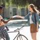african american student with bicycle and female student with books near college - PhotoDune Item for Sale