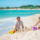Father with daughter playing with sand on tropical beach. Family playing with beach toys - PhotoDune Item for Sale