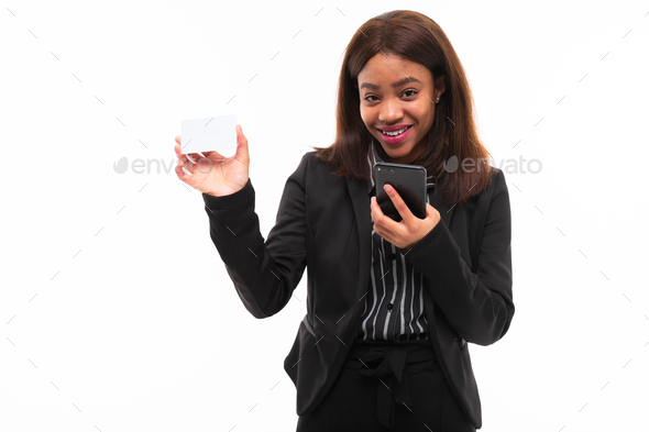 dark-skinned young smilling girl handing a card while speaking on phone isolated on white background