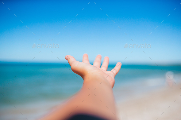 Closeup hand on background of the sea and sky - Stock Photo - Images