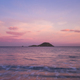 Pink color sunset on the ocean with island in background. Concept of travel and scenic place - PhotoDune Item for Sale