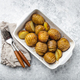 Hasselback baked potatoes in white ceramic casserole dish on white concrete table background - PhotoDune Item for Sale