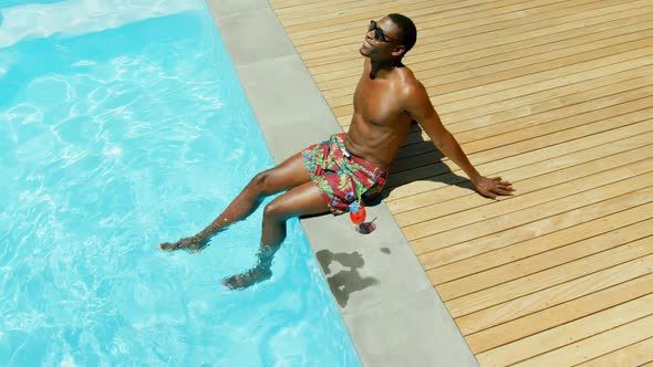 High angle viewof black man rlaaxing with his feet in swimming pool 4k alt