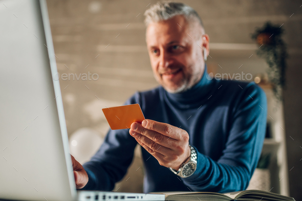 Focus on a gold credit card in a middle aged man hands