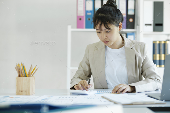 Accountant is working on her desk by using her calculator. - Stock Photo - Images