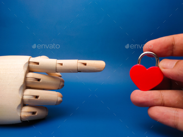 Someone hand holding love padlock with wooden hand on a blue background. - Stock Photo - Images