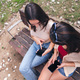 friends having fun on a park bench looking phone - PhotoDune Item for Sale