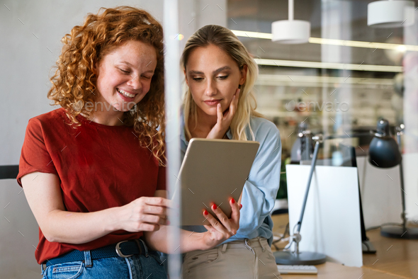 Portrait of happy young business women, designers smiling while working together in office - Stock Photo - Images