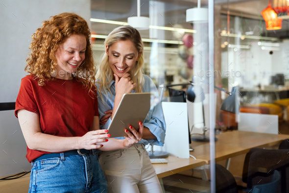 Happy smiling business women working together online on a tablet in office - Stock Photo - Images