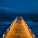 illuminated pier with dramatic sky over stormy dark sea at evening, Varna Bulgaria - PhotoDune Item for Sale